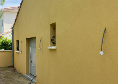 Ravalement de façade avec application d’un enduit extérieur sur maison individuelle.